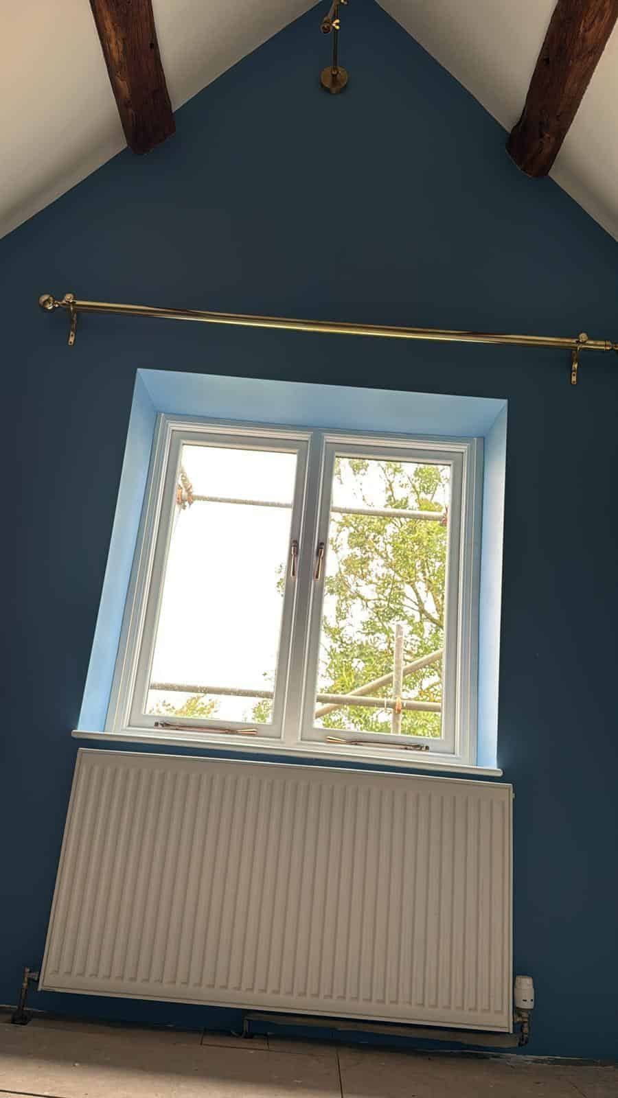Cottage bedroom with deep blue walls and exposed beams