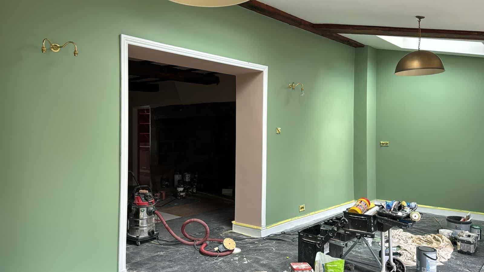 Sage green living room with beams and French doors