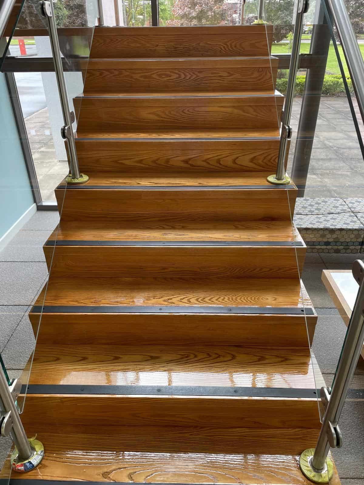 Varnished timber staircase with glass balustrade