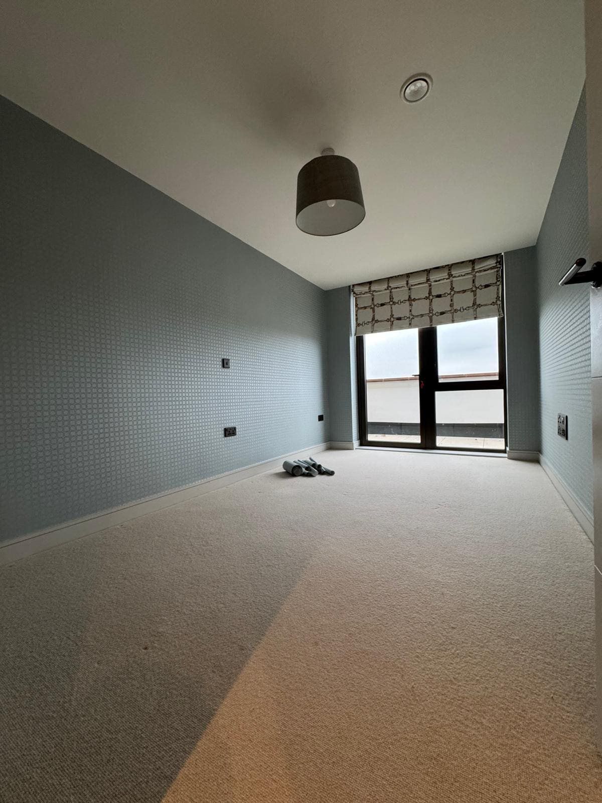 Grey wallpapered bedroom with window