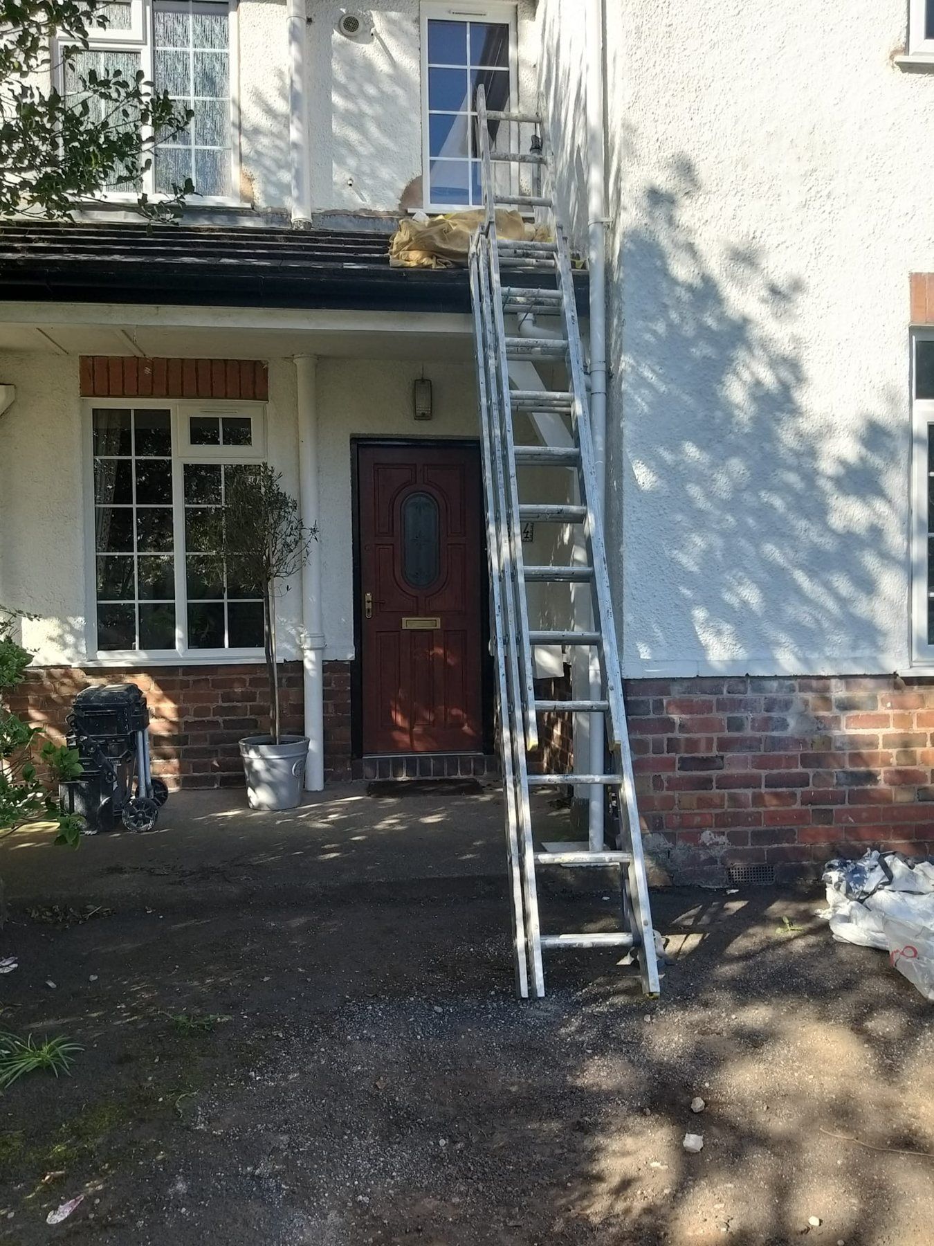 House front during exterior painting with ladder
