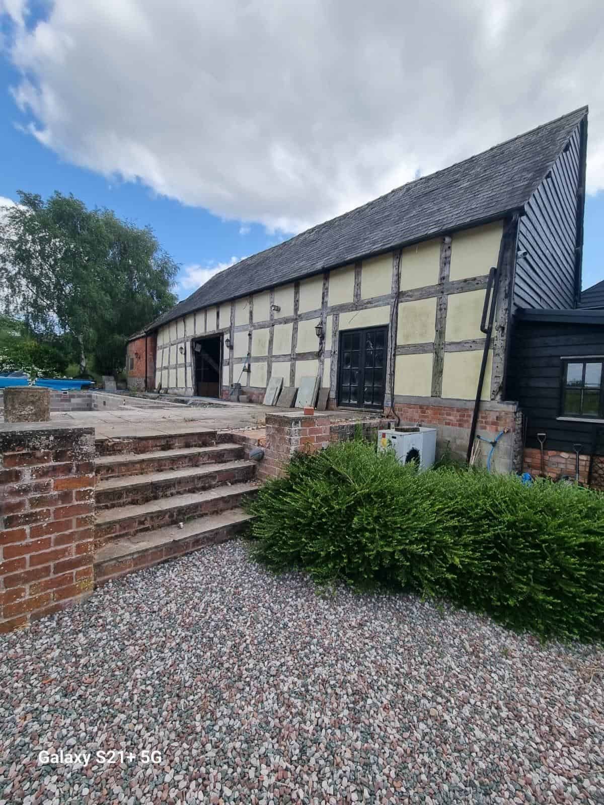 Long elevation of the timber-framed barn after painting