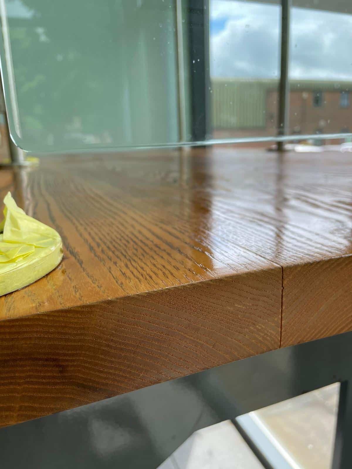 Varnished tread next to glass panel
