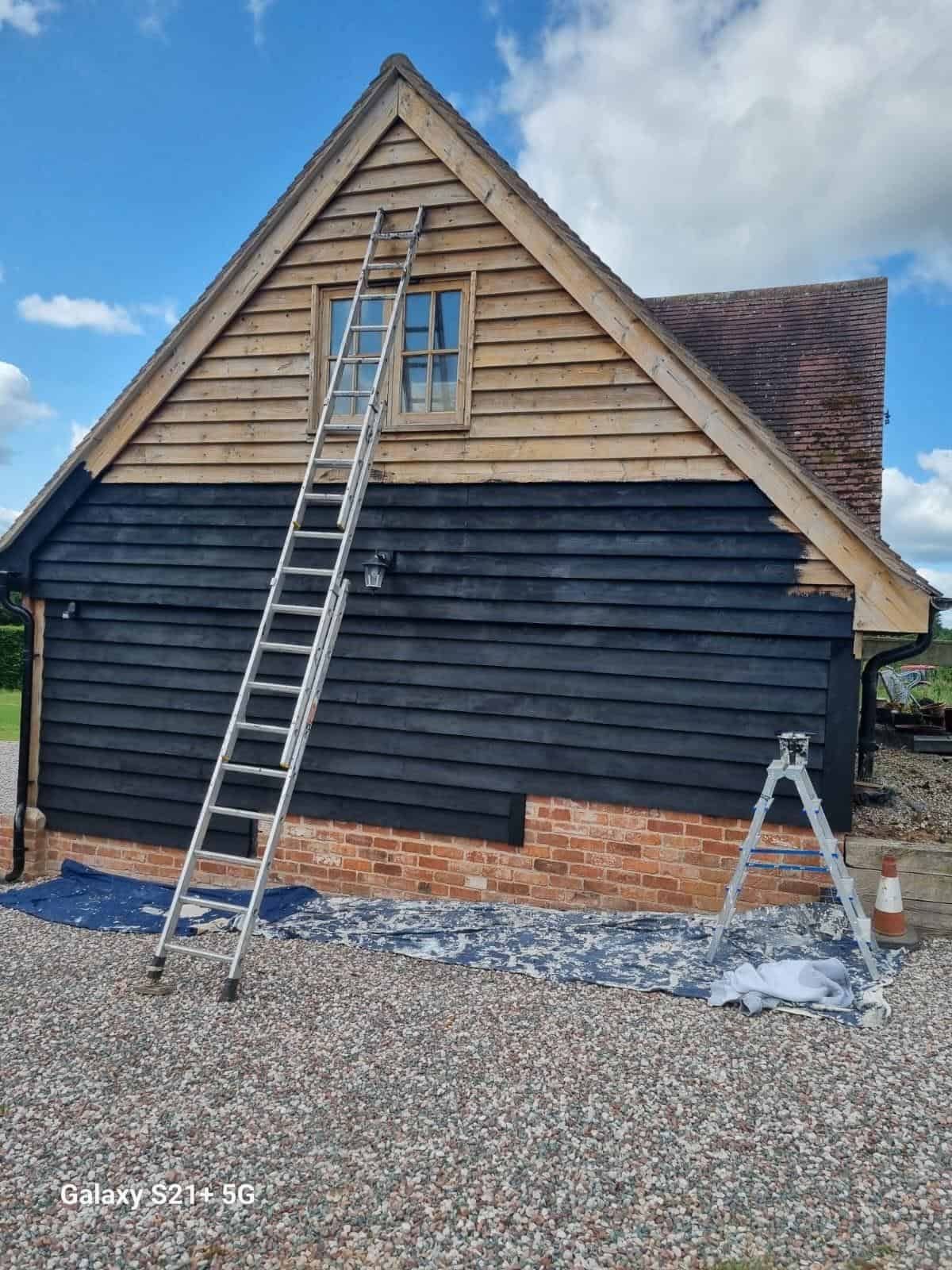 Weatherboard gable during painting with ladder