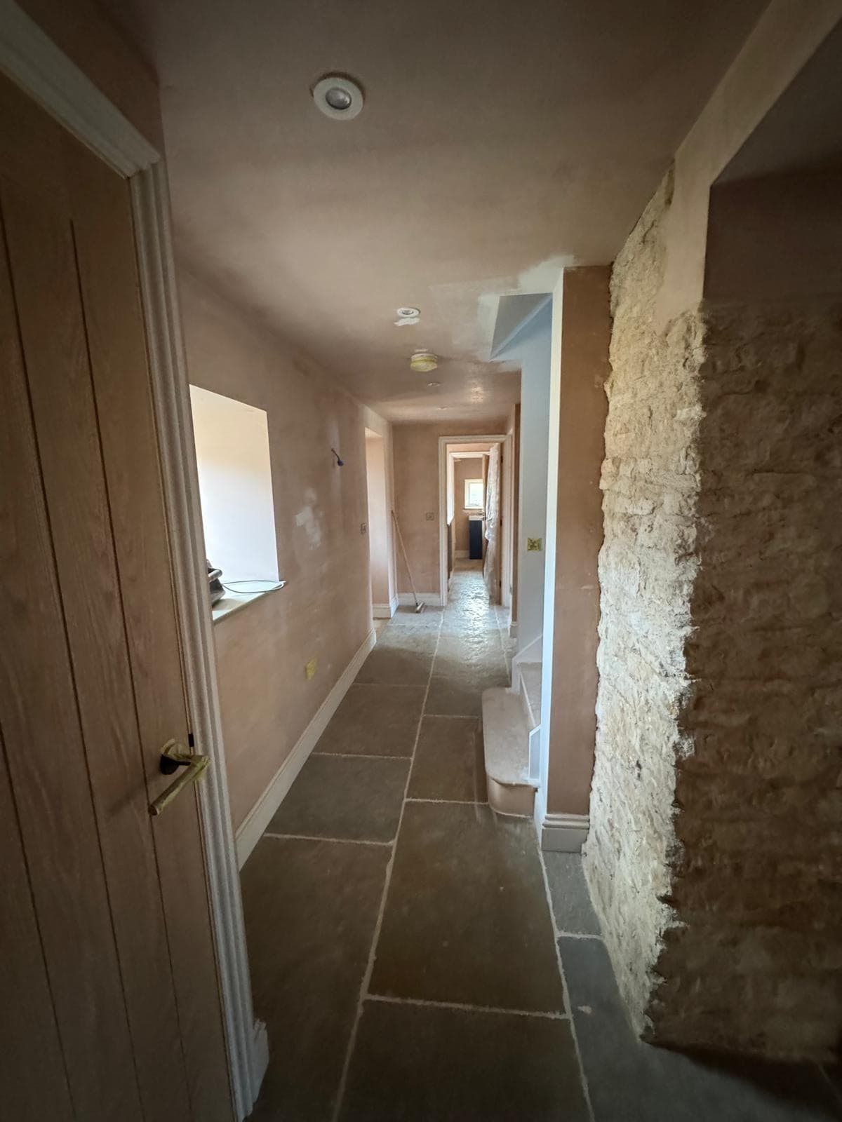 Corridor alongside exposed stone wall